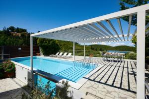 a white pergola over a swimming pool at Sivota Senses - Villa Loukas in Sivota +7 photos