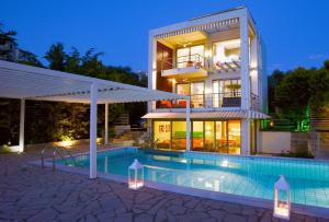 una casa con piscina frente a una casa en Sivota Senses - Villa Loukas en Syvota