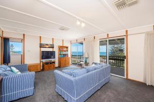 a living room with two blue couches and a television at Ocean Vista Large Modern Home With Ocean Views in Guilderton