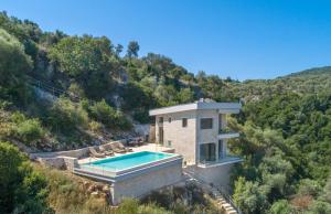 a house on a hill with a swimming pool at Spilia Bay House in Spartokhórion
