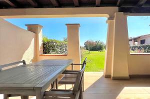 a wooden table and chairs on a patio at ISS Travel, San Teodoro 1 - 100 m from Cala d'Ambra Beach in San Teodoro
