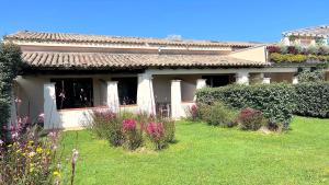 a house with a yard with flowers in front of it at ISS Travel, San Teodoro 1 - 100 m from Cala d'Ambra Beach in San Teodoro