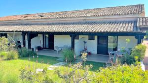a white house with a patio and a yard at ISS Travel, San Teodoro 1 - 100 m from Cala d'Ambra Beach in San Teodoro +17 photos