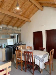eine Küche mit einem Tisch und Stühlen sowie eine Küche mit einem Herd in der Unterkunft Casa do Moura in Arcos de Valdevez