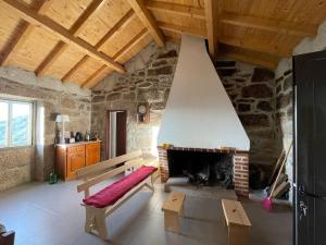 a living room with a fireplace and a bench at Casa do Moura in Arcos de Valdevez