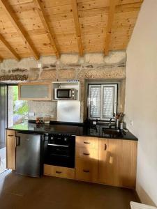 a kitchen with a stove and a microwave at Casa do Moura in Arcos de Valdevez