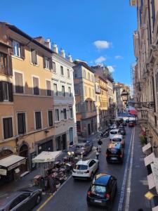 una concurrida calle de la ciudad con coches aparcados en la carretera en RomAntic Dreams Sistina Guest House, en Roma