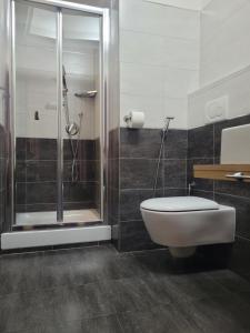 een badkamer met een toilet en een glazen douche bij RomAntic Dreams Sistina Guest House in Rome