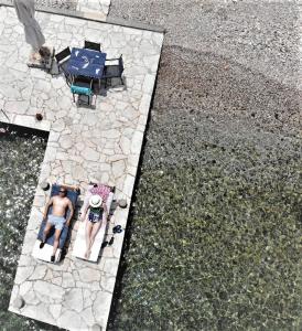 an aerial view of a man sitting on a patio at Symi . VILLA CALME (Sur la Mer). in Symi