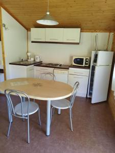a kitchen with a table and chairs and a refrigerator at chez Sabine et Bertrand in Beynat