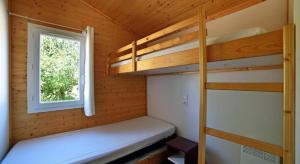 a bedroom with two bunk beds and a window at chez Sabine et Bertrand in Beynat