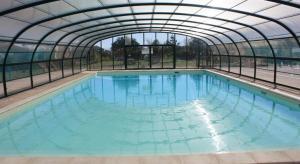 a large swimming pool with a glass tunnel at chez Sabine et Bertrand in Beynat