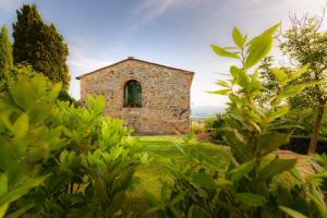 an old stone building with a window in a yard at Monti 1824 - Apartments & Cottages in Casole dʼElsa