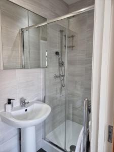 uma casa de banho com um lavatório e um chuveiro em Studio Rooms Ensuite Newbury Park London em Seven Kings