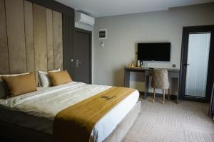 a hotel room with a large bed and a desk at Aram Otel Business & Luxury in Istanbul