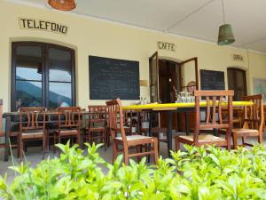 a restaurant with wooden chairs and a table and a chalkboard at Locanda del Santuario in Campiglia Cervo