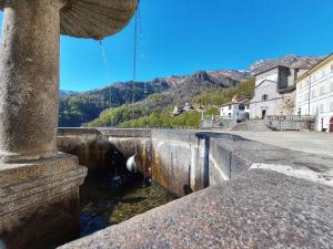 un canale d'acqua in una città con montagne sullo sfondo di Locanda del Santuario a Campiglia Cervo