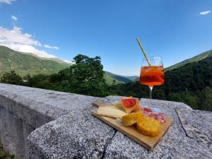 - une assiette de nourriture et une boisson assises sur un grand livre dans l'établissement Locanda del Santuario, à Campiglia Cervo