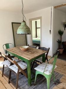 a green table and chairs in a living room at The Old Soap House - stylish and close to beach in Vang