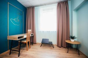 escritorio y silla en una habitación con ventana en La Casa, en Ventspils