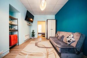 uma sala de estar com um sofá e uma parede azul em La Casa em Ventspils
