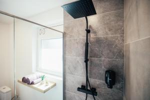 a bathroom with a shower with a black shower head at La Casa in Ventspils