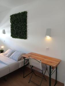 a bedroom with a desk and a bed with a table at Costa by the Beach in Costa da Caparica