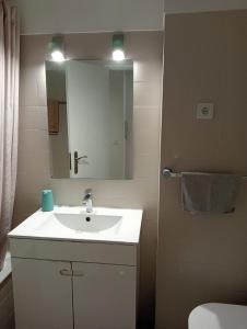 a bathroom with a white sink and a mirror at Costa by the Beach in Costa da Caparica