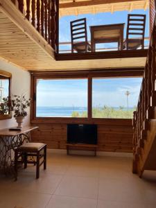 a living room with a view of the ocean at Nashos Bungalows in (( Spile ))