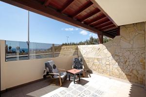 a balcony with two chairs and a table and windows at Laikas house in Costa Calma