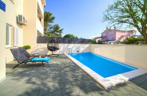 una piscina con una sedia accanto a un edificio di Apartment NB a Šilo