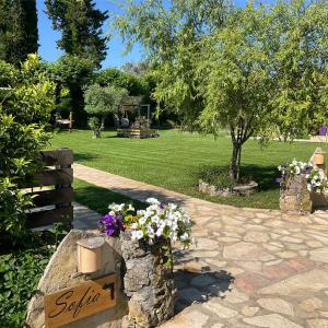 a sign for a garden with flowers in a park at Las plantas-studios-apartments-Corfu in Dassia