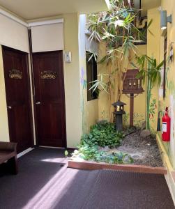 een kamer met 2 houten deuren en een tuin bij Sala Boutique Hotel in Male City