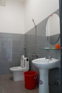 a bathroom with a sink and a toilet and a mirror at Hương Tràm in Hồ Ðá