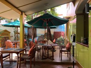 a patio with tables and chairs and an umbrella at Sala Boutique Hotel in Male City