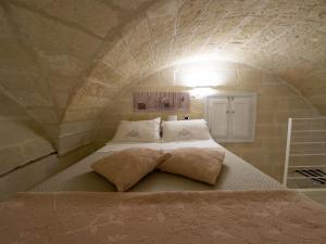 a bedroom with a bed in a stone wall at Antica Cisterna di Lecce in Lecce