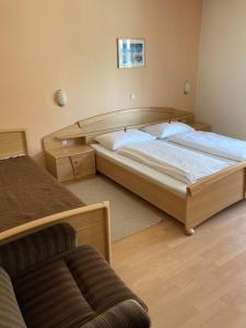 1 dormitorio con 2 camas y sofá en Gasthof zum Goldenen Löwen - Nebenhaus, en Ehrenhausen