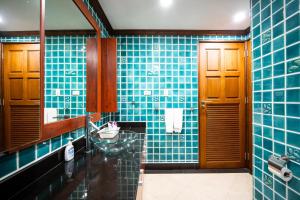 a blue tiled bathroom with a sink and a mirror at Patong Tower Duplex Seaview 4BR-2901 in Patong Beach +29 photos