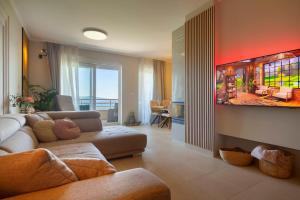 uma sala de estar com um sofá e uma televisão de ecrã plano em Seaview apartment with the pool em Crikvenica