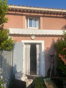 a house with a door and a chair in front of it at Appartement les sablas in Saint-Tropez