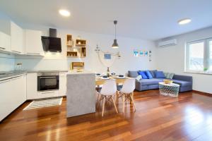 una cucina e un soggiorno con un tavolo e un divano di Apartment NB a Šilo