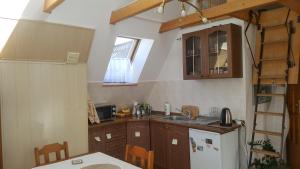 a kitchen with wooden cabinets and a white refrigerator at Apartament Słoneczny in Zakopane