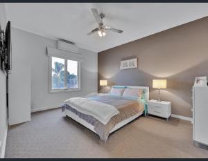 1 dormitorio con 1 cama y ventilador de techo en Golf Views Apartment, en Mulwala