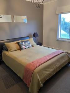 a bedroom with a large bed with a window at Golf Views Apartment in Mulwala