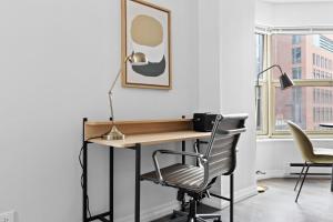 a desk with a chair and a lamp in a room at Gold Coast 1BR w Deck Gym Lounge 1 block to L CHI-650 in Chicago