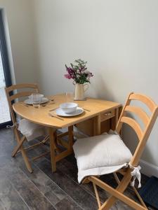 a wooden table with two chairs and a vase with flowers at Newton Bothy in Stirling