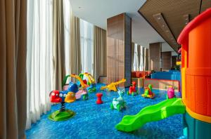 uma sala de jogos para crianças com brinquedos no chão em G8 Luxury Hotel and Spa Da Nang em Da Nang