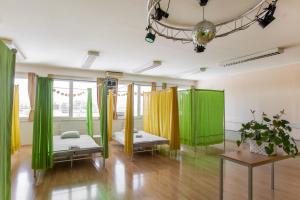 a room with green and yellow curtains and beds at TEJ HOSTEL in Ljubljana