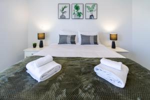 1 dormitorio con 1 cama grande y toallas. en A Road Away from Hagley Park 2 bed 2 bath, en Christchurch