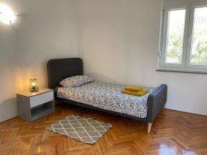 een kamer met een bed, een tafel en een raam bij Apartment Tulip in Premantura